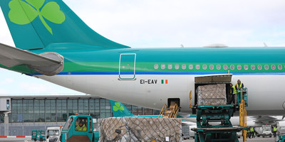 Truck transporting PPE sits in front of Aer Lingus aircraft.