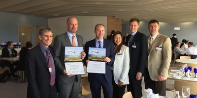 AerCap executives posing for a photo op while holding certificates of purchase.
